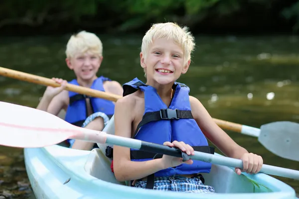 Twee gelukkige school jongens kajakken op de rivier — Stockfoto