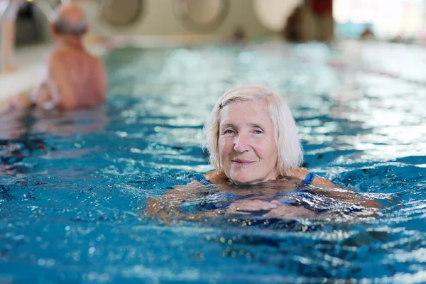 Mulher sênior feliz nadando na piscina — Fotografia de Stock