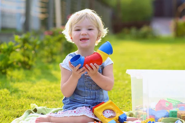 Divertente bambina che gioca con i giocattoli all'aperto — Foto Stock