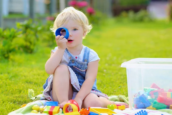 Engraçado menina brincando com brinquedos ao ar livre — Fotografia de Stock