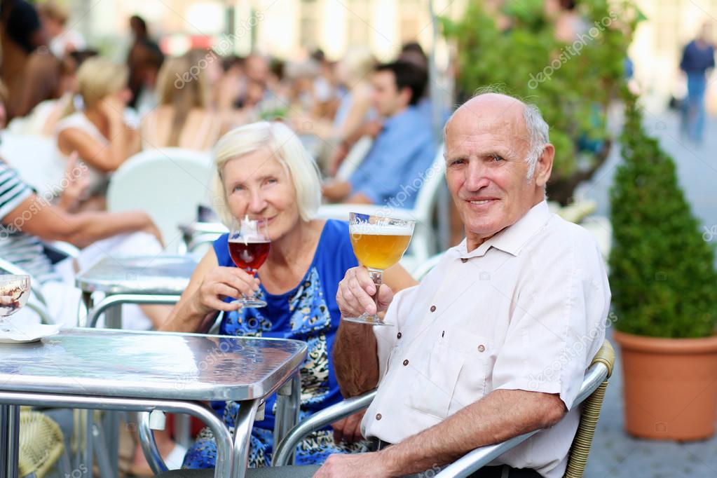 Senior couple drinking beer in outdoors cafe