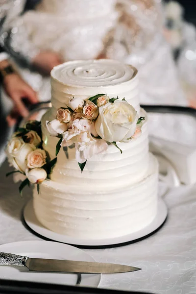 结婚蛋糕 在米色的桌子上享用三层蛋糕 在浅色的背景上享用装饰过的玫瑰 — 图库照片