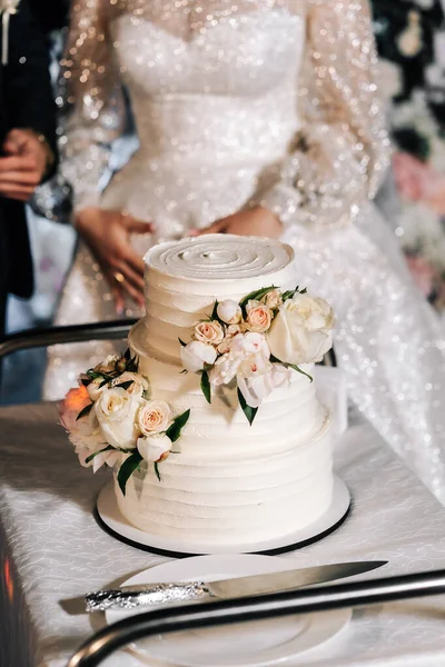 结婚蛋糕 在米色的桌子上享用三层蛋糕 在浅色的背景上享用装饰过的玫瑰 — 图库照片