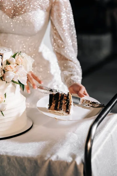 切结婚蛋糕 结婚蛋糕 在米色的桌子上放三层蛋糕 配以淡淡的背景玫瑰 — 图库照片
