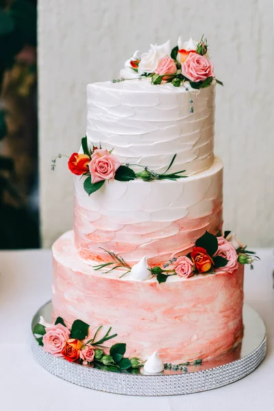 Düğün pastası. Üç kat zemin. Beyaz altın çiçekler.