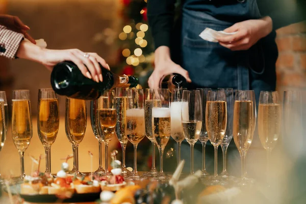 Lokantada şampanyaların sıcak aydınlatmayla doldurulduğu bardaklar var.