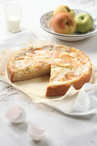 Torta de maçã em papel manteiga, com maçãs frescas — Fotografia de Stock