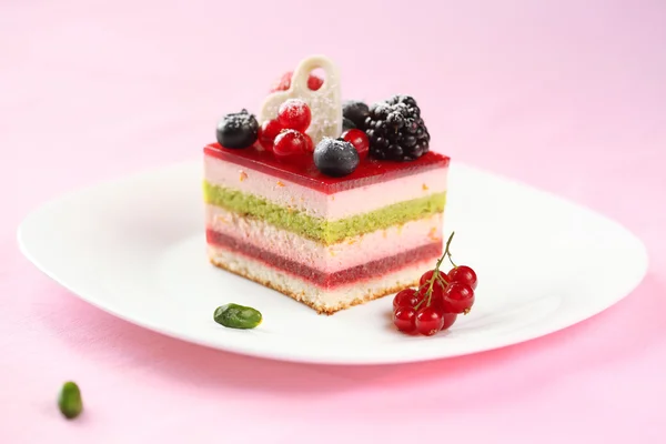 Stuk van multi-gelaagde berry en pistache mousse taart — Stockfoto