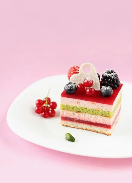 Stück mehrschichtiger Beeren- und Pistazienmoussekuchen — Stockfoto