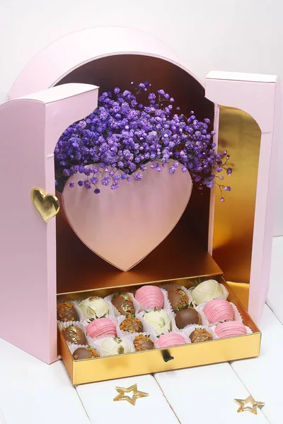 분홍색 상자에 초콜릿을 딸기를 배경에 놓아두었다 — 스톡 사진