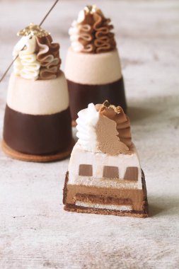 Duble çikolatalı Mini Mousse Kekleri, çikolataya batırılmış, çırpılmış beyaz çikolata kreması ve çikolata dallarıyla süslenmiş, açık arkaplanda..
