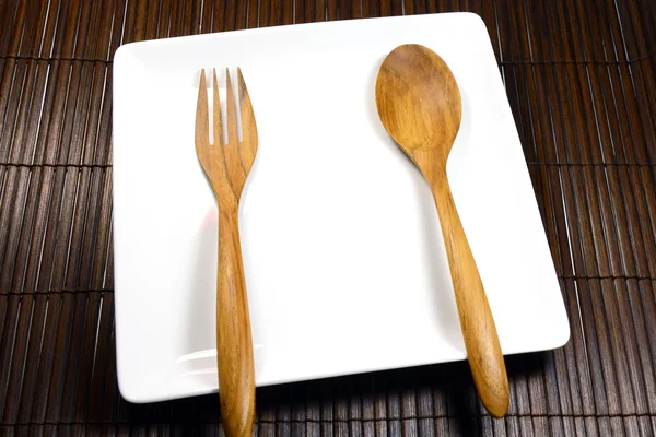 Wooden Fork and Spoon on Earthenware White Dish. — Stock Photo, Image