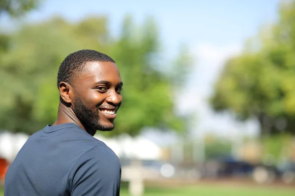 Hombre Negro Feliz Mirando Cámara Caminando Parque —  Fotos de Stock