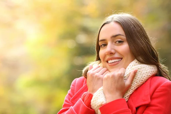 公園で秋にカメラを見て暖かさを保つ赤の幸せな女性 — ストック写真
