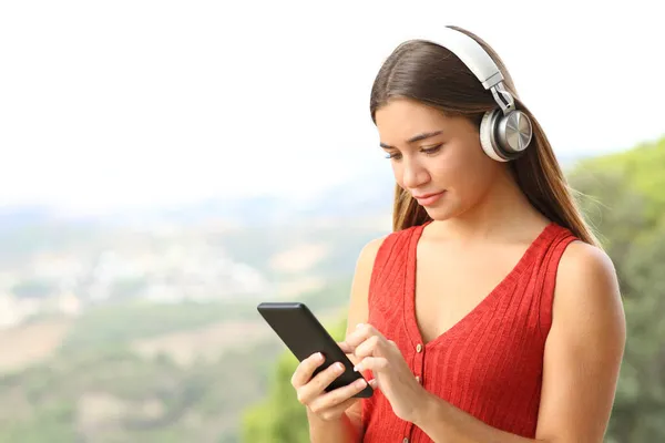 Teenager Červené Nosí Sluchátka Poslech Hudby Kontrolu Telefonu Venku — Stock fotografie