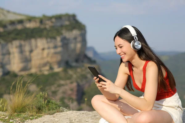 Uçurumda Müzik Dinleyen Kulaklık Takan Mutlu Asyalı Kadın — Stok fotoğraf