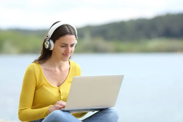 Happy Woman Wearing Headset Using Laptop Sitting Lake — Stock Photo, Image