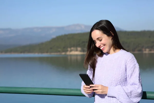 Ευτυχισμένη Γυναίκα Που Χρησιμοποιεί Smartphone Μια Λίμνη Χειμώνα — Φωτογραφία Αρχείου