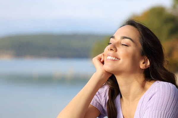 Happy woman enjoying peace sitting in a beautiful lake