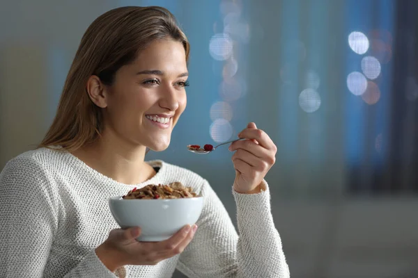 Mulher Feliz Comendo Cereais Olhando Para Longe Noite Casa — Fotografia de Stock