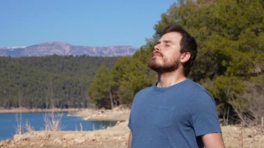 Yakışıklı adam gölde temiz hava soluyor.