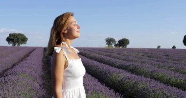 Mutlu güzel kadın lavanta tarlasında temiz hava soluyor.