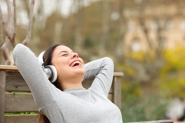 Mujer Feliz Escuchando Música Usando Auriculares Relajándose Sentada Banco Parque — Foto de Stock
