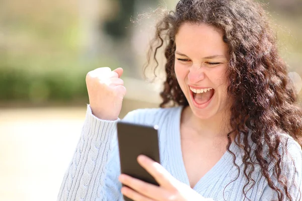 Ενθουσιασμένη Γυναίκα Γιορτάζει Καλά Νέα Ελέγχοντας Smartphone Ένα Πάρκο — Φωτογραφία Αρχείου