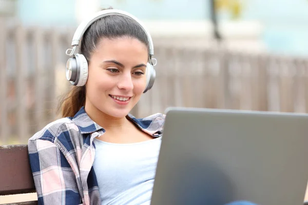 Happy Teen Wearing Headphones Using Laptop Sitting Bench Park — Stock fotografie