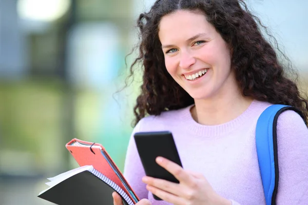 Estudiante Feliz Mirando Cámara Que Sostiene Teléfono Inteligente Campus —  Fotos de Stock