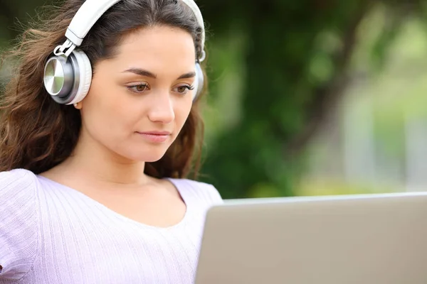 Konzentrierte Frau Mit Drahtlosen Kopfhörern Beobachtet Medien Auf Laptop Einem — Stockfoto
