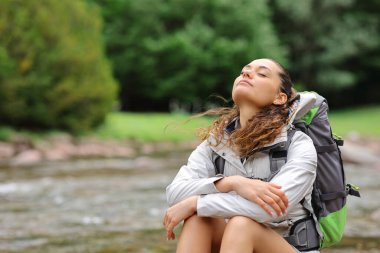 Trekker, dağın yamacında dinleniyor ve temiz hava soluyor.