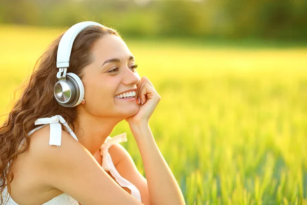 Buğday Tarlasında Oturmuş Kablosuz Kulaklıkla Müzik Dinleyen Mutlu Bir Kadın — Stok fotoğraf