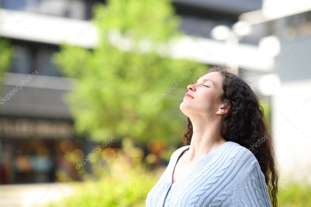 Profile of a woman relaxing breathing fresh air in the street