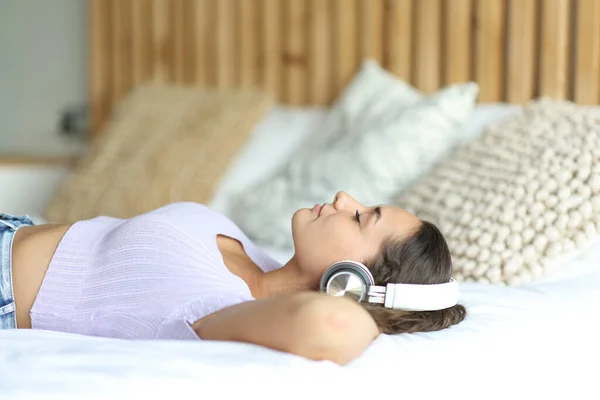 Kablosuz Kulaklık Takan Yatakta Müzik Dinleyen Bir Kadının Yan Görüntüsü — Stok fotoğraf