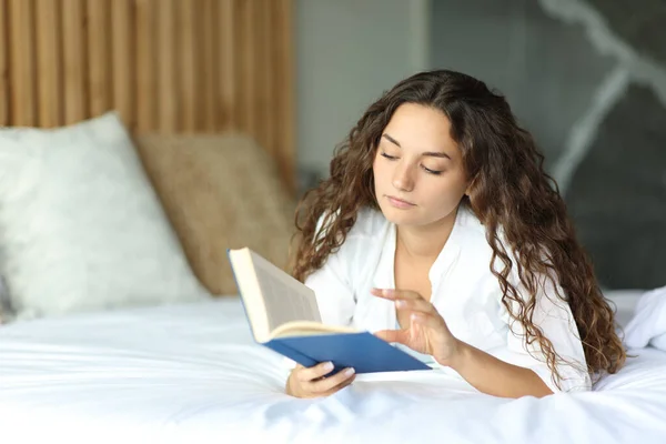 Concentrated Woman Hotel Bed Reading Paper Book — Zdjęcie stockowe