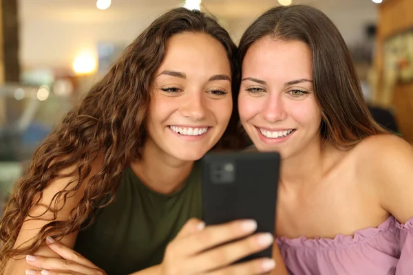 Two Happy Women Smiling Checking Smart Phone Together Bar — Φωτογραφία Αρχείου