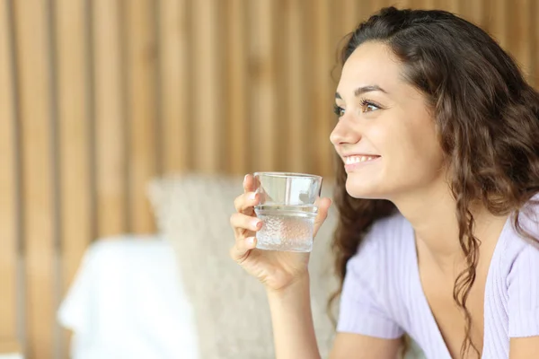 Happy Woman Looking Away Holding Water Glass Sitting Bed Bedroom — Stock Photo, Image