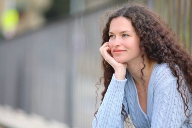 Relaxed and satisfied woman contemplating sitting in the street