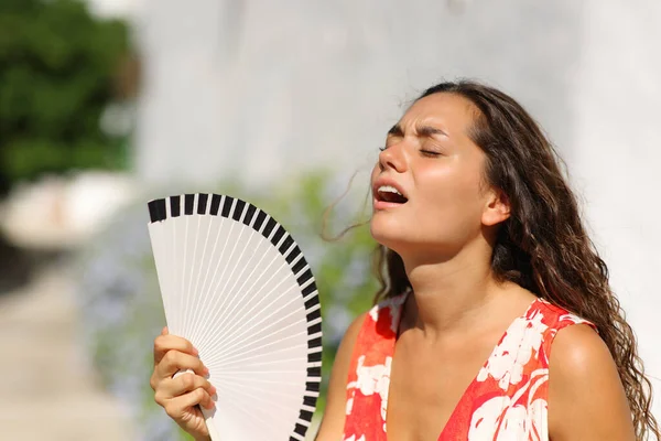 Woman suffering heat stroke in a town street on summer