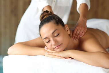 Massage therapist working with a happy client in a spa