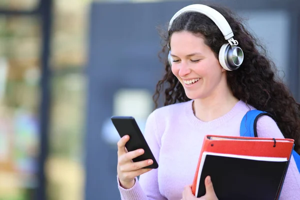 Ευτυχής Φοιτητής Φορώντας Ακουστικά Περπατά Ακούγοντας Ήχο Στο Τηλέφωνο — Φωτογραφία Αρχείου