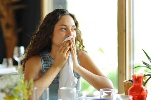 一个女人坐在餐馆里用餐巾擦着嘴 — 图库照片