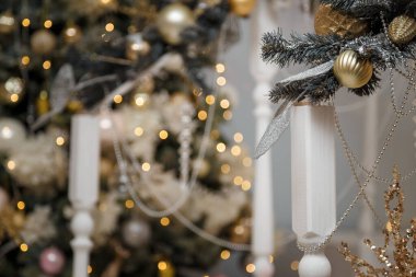 Yumuşak odaklı boncuklar ve köknar ağacına takılan altın takılar ve altın gibi parlak Noel ışıkları arka planda. Şenlikli atmosfer, tatil ruhu, yeni yıl kutlaması konsepti..