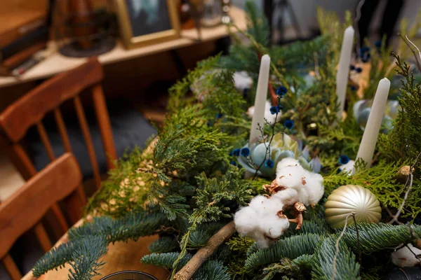 柔らかい素朴なスタイルのクリスマスのお祝いのテーブル 新鮮なThuja 綿の枝の花束 白いキャンドルのショットをクローズアップ焦点を当てました 環境に優しい緑の装飾要素 — ストック写真