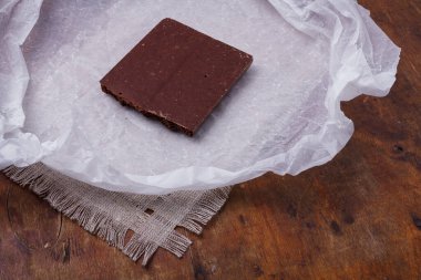 Beyaz kağıtta gözenekli çikolata. Kabarcıklı ya da süngerimsi çikolata, lezzetli tatlılar, karbonhidratlı yiyecekler, tatlı cazibe, sağlıksız beslenme