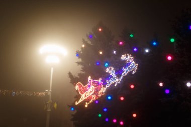 Şehirde Noel ağacının çelenklerle süslenmiş gece çekimleri. Mutlu yıllar, Mutlu Noeller, kış tatili konsepti.