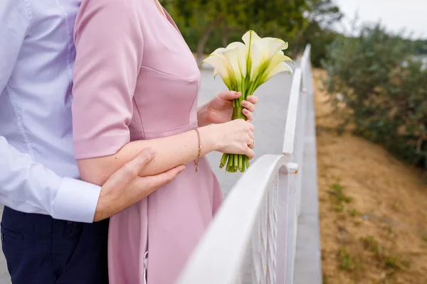 Bräutigam Umarmt Braut Rosa Kleid Hält Weißen Calla Lilien Strauß — Stockfoto