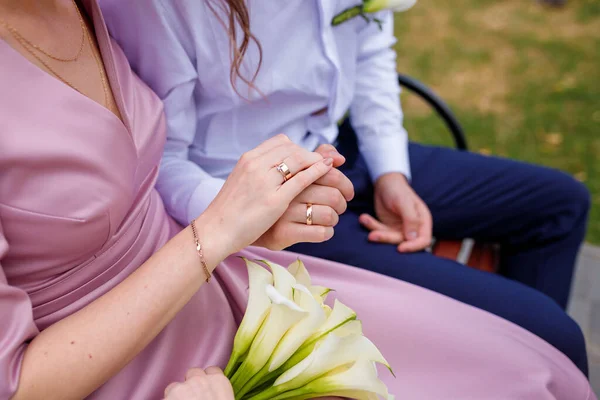 Bräutigam Und Braut Sitzen Auf Der Bank Zärtlich Händchen Haltend — Stockfoto