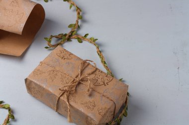 Sarılı Mutlu Noeller hediye kutusu. Kırsal kağıt ve beyaz üzerine jute halat yayı. Plastiksiz, yeşil Noel konsepti. Boşluğu kopyala.